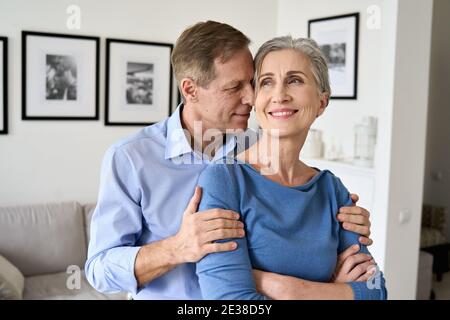Glückliches älteres Paar umarmt, Bonding, wegschauen träumen von einer guten Zukunft. Stockfoto