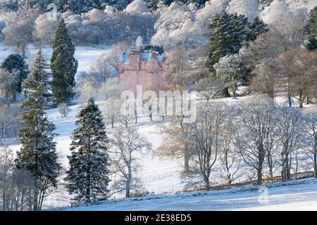 Craigievar Castle eingebettet zwischen den Bäumen auf einem Snowy bewaldeten Hügel in Schottland Stockfoto