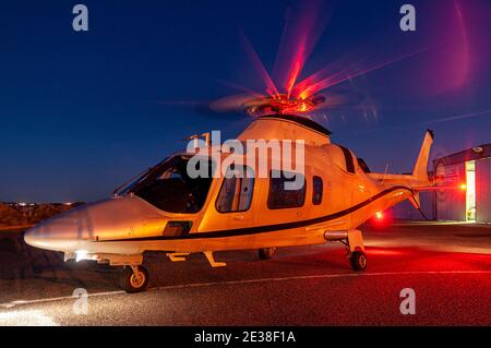 Ein Agusta 109 Power Executive Hubschrauber bei Sonnenuntergang. Stockfoto