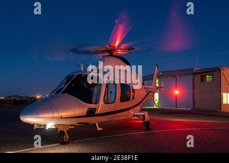 Ein Agusta 109 Power Executive Hubschrauber bei Sonnenuntergang. Stockfoto