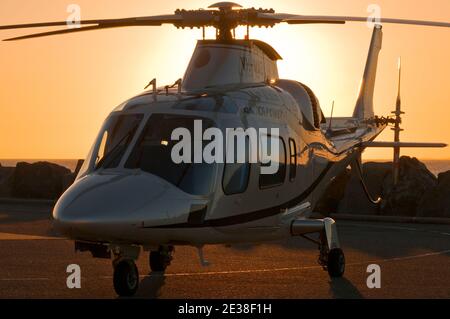 Ein Agusta 109 Power Executive Hubschrauber bei Sonnenuntergang. Stockfoto