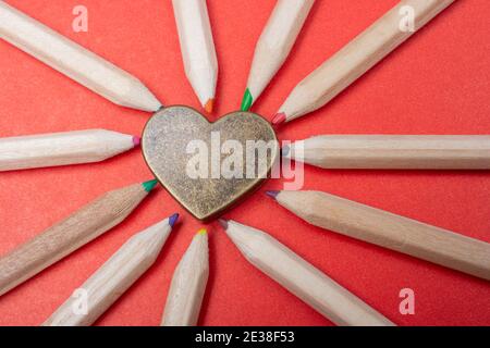 Herz mit geschärften mehrfarbigen Bleistiften ausgelegt Stockfoto