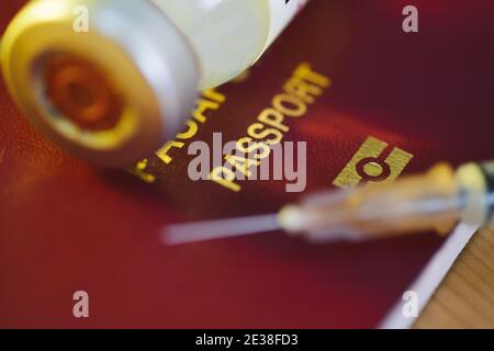 Nahaufnahme einer Coronavirus-Impfstoffflasche und einer Spritze mit einem rot gefärbten türkischen Pass als Impfpass. Stockfoto