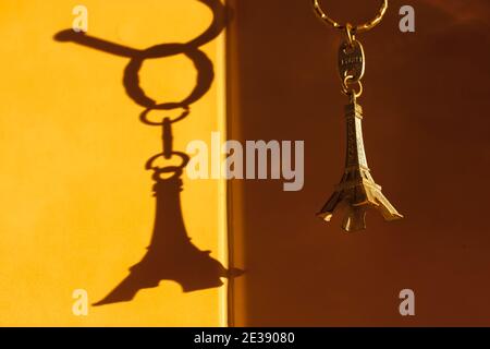 Schlüsselanhänger in Form des Eiffelturms und Kontrast Schatten an der Wand Stockfoto