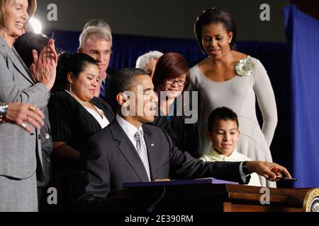 US-Präsident Barack Obama unterzeichnet den Healthy, Hunger-Free Kids Act von 2010 mit First Lady Michelle Obama (R), der 3. Klasse Luis Avilar-Rurcios (2. R) und der 7. Klasse Tammy Nguyen (3. R) an der Harriet Tubman Elementary School in Washington, DC, USA, am 13. Dezember 2010. In dem Bemühen, Kindern bessere Schulessen und besseres Frühstück zu bieten, legt das neue Gesetz 4.5 Millionen US-Dollar in die Hände von Kinderernährungsprogrammen, setzt Ernährungsstandards für Schulautomaten, hilft bei der Schaffung von Schulgärten und stellt sicher, dass während der Mahlzeiten qualitativ hochwertiges Trinkwasser zur Verfügung steht. Foto von Chip Somodevilla/A Stockfoto