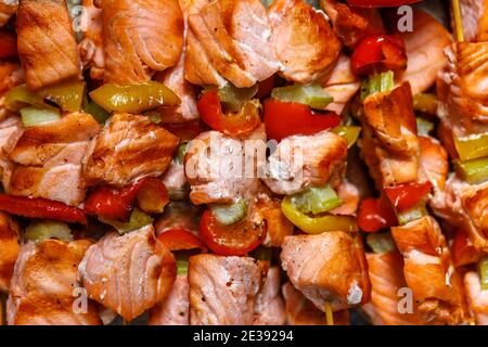 Gegrilltes Gemüse und roter Fisch auf Holzspießen. Der Blick von oben. Stockfoto