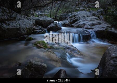 Flusswasser fließt zwischen den Felsen und bildet kleine Wasserfälle, Rascafría, Madrid, Spanien Stockfoto