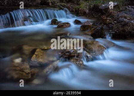 Flusswasser fließt zwischen den Felsen und bildet kleine Wasserfälle, Rascafría, Madrid, Spanien Stockfoto