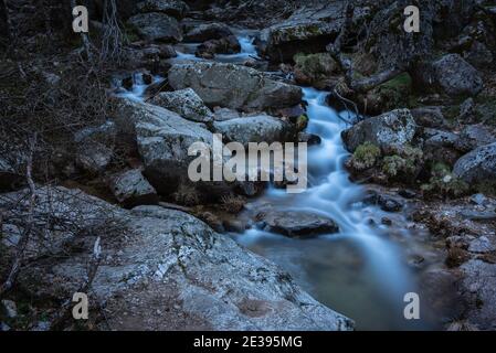 Flusswasser fließt zwischen den Felsen und bildet kleine Wasserfälle, Rascafría, Madrid, Spanien Stockfoto