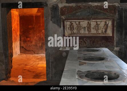 Ein Blick auf das Thermopolium des Vetutius Placidus in Pompeji, Süditalien am 25. November 2010. Das Thermopolia war eine Art Snack-Bar, wo man warme Speisen und Getränke bekam. Die antike römische Stadt Pompeji, die vor 2,000 Jahren in vulkanischer Asche aufbewahrt wurde, leidet unter Verfall. Archäologen sagen, dass es durch Vandalismus, Verschmutzung und Vernachlässigung ruiniert wird. Ihre Schätze sind nun in großer Gefahr, für immer verloren zu sein. Am 6. November brach Pompejis Haus der Gladiatoren zusammen und der Rest der außergewöhnlichen antiken Stadt befindet sich in einem gefährlichen Zustand. Pompeji wurde 79 n. Chr. durch einen Ausbruch des Vesuv zerstört. Stockfoto