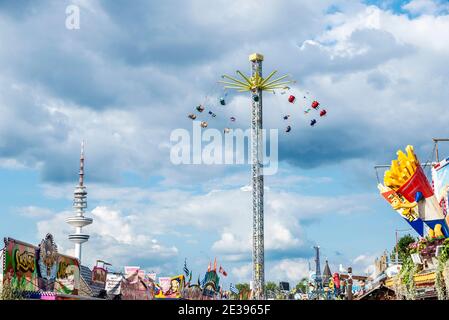 Hamburg, Deutschland - 21. August 2019: Attraktion des rotierenden Pendels mit Menschen rund um die Hamburg DOM , Freizeitpark am Sommer und der telec Stockfoto