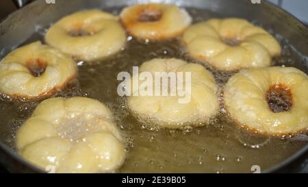 Braten Kochen hausgemachte Donuts auf heißem kochendem Öl, Fett Essen preparation.Donuts Stockfoto