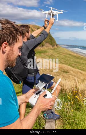 Freunde fliegen Drohne zusammen - Gruppe von zwei Jungs mit Spaß beim Spielen mit Drohne im Freien beim Start Stockfoto