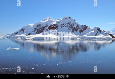 Antarktis, hohe Gipfel spiegeln sich in den stillen Gewässern von Paradise Harbour mit schönen Reflexionen Stockfoto