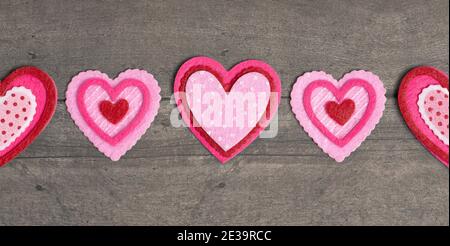 Einfacher Hintergrund mit Filz Love Hearts auf einem Holztisch Stockfoto