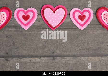 Einfacher Hintergrund mit Filz Love Hearts auf einem Holztisch Stockfoto