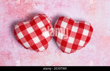 Karierte Love Hearts auf einem strukturierten rosa Hintergrund Stockfoto
