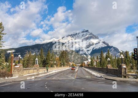 Banff Avenue im verschneiten Herbst sonnigen Tag. Schneebedeckter Cascade Mountain mit blauem Himmel und weißen Wolken im Hintergrund. Banff National Park Stockfoto