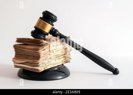 Weißer Hintergrund auf einem Richterhammer von einem großen unterstützt Anzahl der übereinander positionierten Banknoten Stockfoto