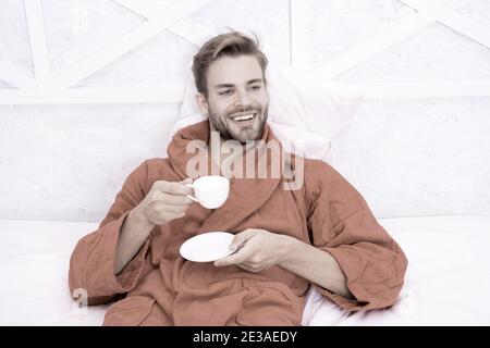 Ab Tag mit guten Kaffee. Entspannt zu Hause. Angenehme Momente. Gourmet Espresso. Kaffee am Morgen genießen. Gerne morgen. Schöner Mann trinken Kaffee am Morgen. Happy bärtiger Mann im Bett. Gute Laune. Stockfoto