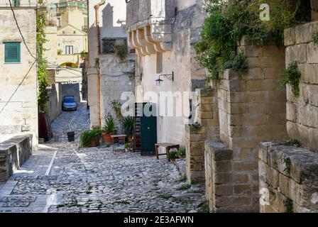Ein silbergestreifter Tabby steht auf seinen Hinterbeinen auf einem Vorsprung auf einer gepflasterten Straße in der alten sassi Stadt Matera, Italien. Stockfoto