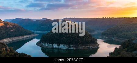 Fluss mäandert Landschaft Panorama bei Sonnenuntergang. Isoliertes religiöses Kloster in Einsamkeit auf einem Berg. Sant Pere de Casserres, Riu Ter, Sau Reservation Stockfoto