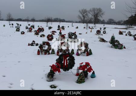 Weihnachtskränze und Weihnachtsdekorationen im Schnee in einem Vorort Chicago Friedhof mit Schnee Stockfoto