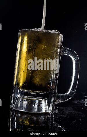 Eiskalte Bierzapfbrauerei vom Fass Studio Stillleben vor schwarzem Hintergrund Stockfoto