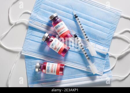 Drei Impfglasflaschen zur Impfung gegen COVID-19 und Spritzen Stockfoto