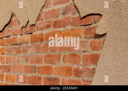 Shabby chic Textur Hintergrund einer alten roten Lehmziegel Wand, unter einem Peeling und verschlechternden sandigen braunen Farbe Stuckwand ausgesetzt Stockfoto