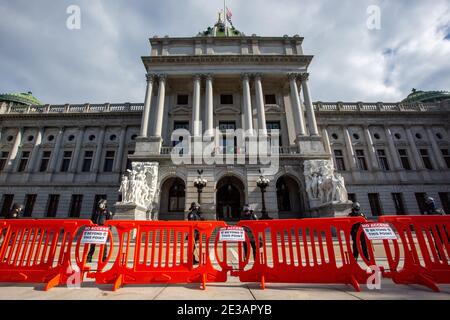 Harrisburg, Usa. Januar 2021. Die Polizei des Pennsylvania Capitol steht hinter orangen Barrikaden, die vor dem Pennsylvania State Capitol errichtet wurden.Berichte über einen möglichen bewaffneten Protest führten zur Schließung des Pennsylvania Capitol und zu einer zusätzlichen Sicherheitspräsenz von Pennsylvania Capitol Police, State Police, Harrisburg Police und der Pennsylvania National Guard. Kredit: SOPA Images Limited/Alamy Live Nachrichten Stockfoto