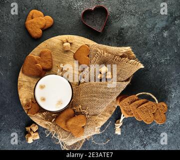 Herzförmige Lebkuchenkekse mit einer Tasse Cappuccino Auf einem Holzbrett Stockfoto