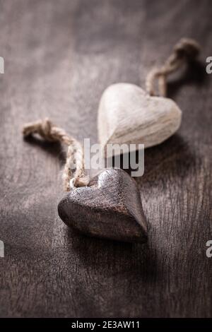 Schwarz und Weiß: Zwei Holzherzen auf Holzgrund Stockfoto