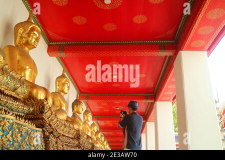 Besucherfotos der Gruppe sitzender Buddha-Bilder im Kloster Wat Pho oder Tempel des aufgehenderen Buddha, Bangkok, Thailand Stockfoto