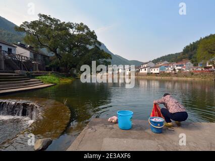 Waschen von Kleidung im lokalen Fluss, Zhongcun ein Bergdorf in der Nähe von Ningbo, China. Eine alte Tradition, die immer noch gepflegt wird. Stockfoto