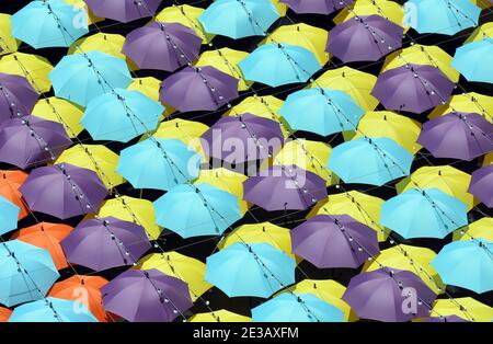 Hunderte von Regenschirmen schützen Käufer vor der Sonne in Shenzhen, China. Reihen von bunten Brollies, um die Sonne draußen zu halten. Viele interessante Muster. Stockfoto