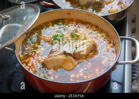 Eine traditionelle hausgemachte Gulasch-Suppe, die in einem kochenden Topf zubereitet wird und aus Rindfleisch-Kurzrippchen und Gemüse besteht Stockfoto