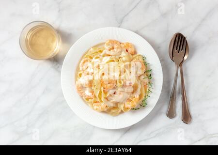 Italienische Pasta. Pappardelle mit Garnelen und Sahnesauce, obenliegend mit Wein erschossen Stockfoto