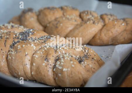 Traditionelles, vorgebackenes Challah-Brot aus Dinkelmehl, mit Belag aus Sesam und Mohn Stockfoto