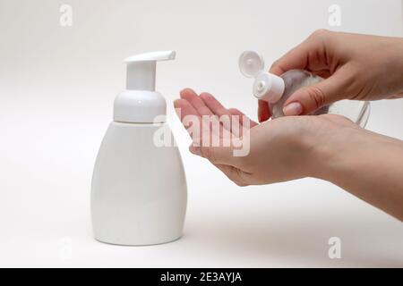 Frauen Hände auf einem weißen Hintergrund halten eine Flasche antiseptischen Gel. Stockfoto