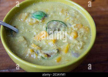 Asiatische Linsen und Butternut-Kürbissuppe, mit thailändischen Auberginen, in einer grünen Schüssel serviert Stockfoto