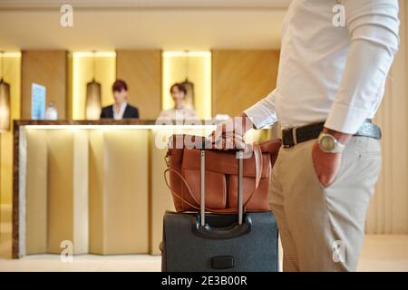 Zugeschnittenes Bild von Hotelgästen, die mit Gepäck in der Lobby stehen Nach dem Einchecken Stockfoto