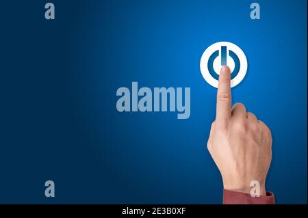 Hand des Geschäftsmannes, der die ein-/aus-Taste drückt. Start-up-Geschäftskonzept. Man Power-up-Konzept. Ein-/Ausschalter des Armes drücken. Blauer Hintergrund, kopieren Sie den SPAC Stockfoto
