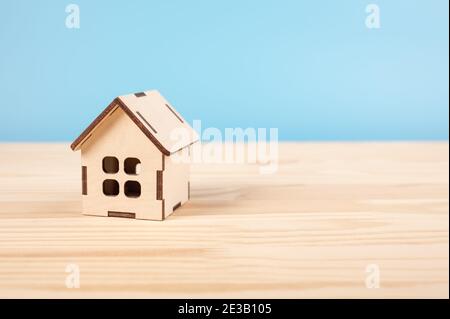 Spielzeughaus auf Holztisch auf blauem Boden. Hypothek-Immobilien-Versicherung Traum-Haus-Konzept. Kopieren Raum. Haus, Versicherung und Hypothek, Bul und ren Stockfoto