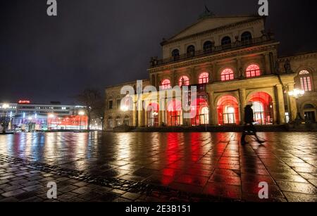 Hannover, Deutschland. Januar 2021. Am frühen Morgen geht ein Mann über den verlassenen Opernplatz. Eine landesweite nächtliche Ausgangssperre wird wahrscheinlich in den Gesprächen der Bundesländer über eine mögliche weitere Verschärfung der Maßnahmen zur Eindämmung der Corona-Pandemie in Betracht gezogen werden. Kredit: Julian Stratenschulte/dpa/Alamy Live Nachrichten Stockfoto