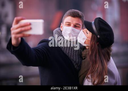 Glückliches Paar feiert Valentinstag in Masken während covid-19 Pandemie Stockfoto