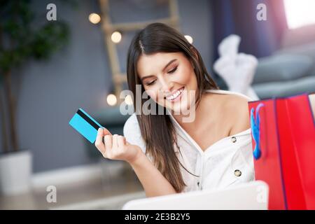 Hübsche Frau, die online mit Kreditkarte zu Hause einkaufen Stockfoto