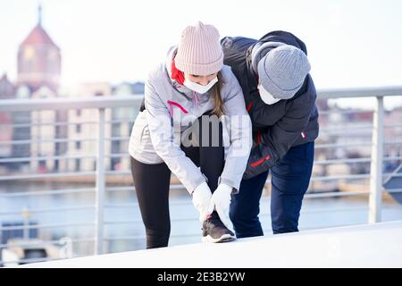 Erwachsenes Paar beim Joggen in der Stadt in Masken während des Lockdown Stockfoto