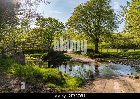 Straße und Fußgängerbrücke über den Skandal Beck bei Smardale, Cumbria, England, Großbritannien Stockfoto