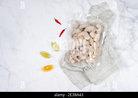 Produkte in Vakuumverpackung auf Holzbrett. Gefrorene Garnelen, vakuumversiegelte Lebensmittel bereit für Sous Vide Kochen. Sous-vide, neue Technologie Küche in qua Stockfoto